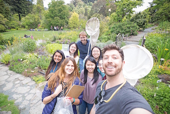 Group of happy students in a garden with nets