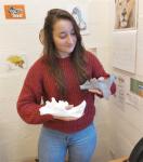 Narimane Chatar holding casts of mandibles from Smilodon and Barbourufelis.