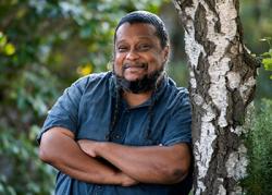 Tyrone Hayes leaning against a tree